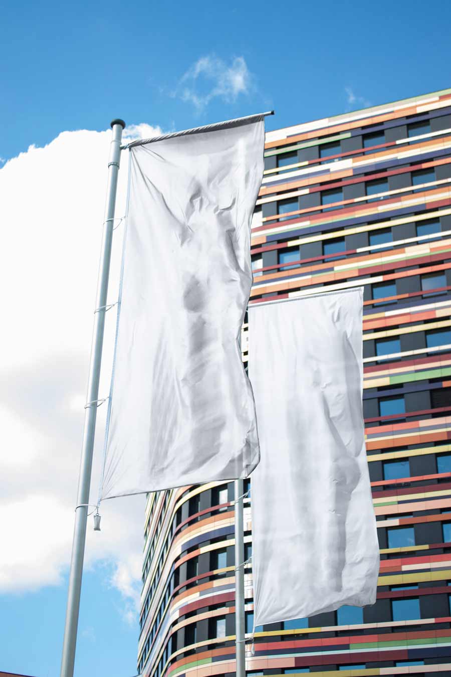 free flag mockup with two vertical blank flags in front of blue sky